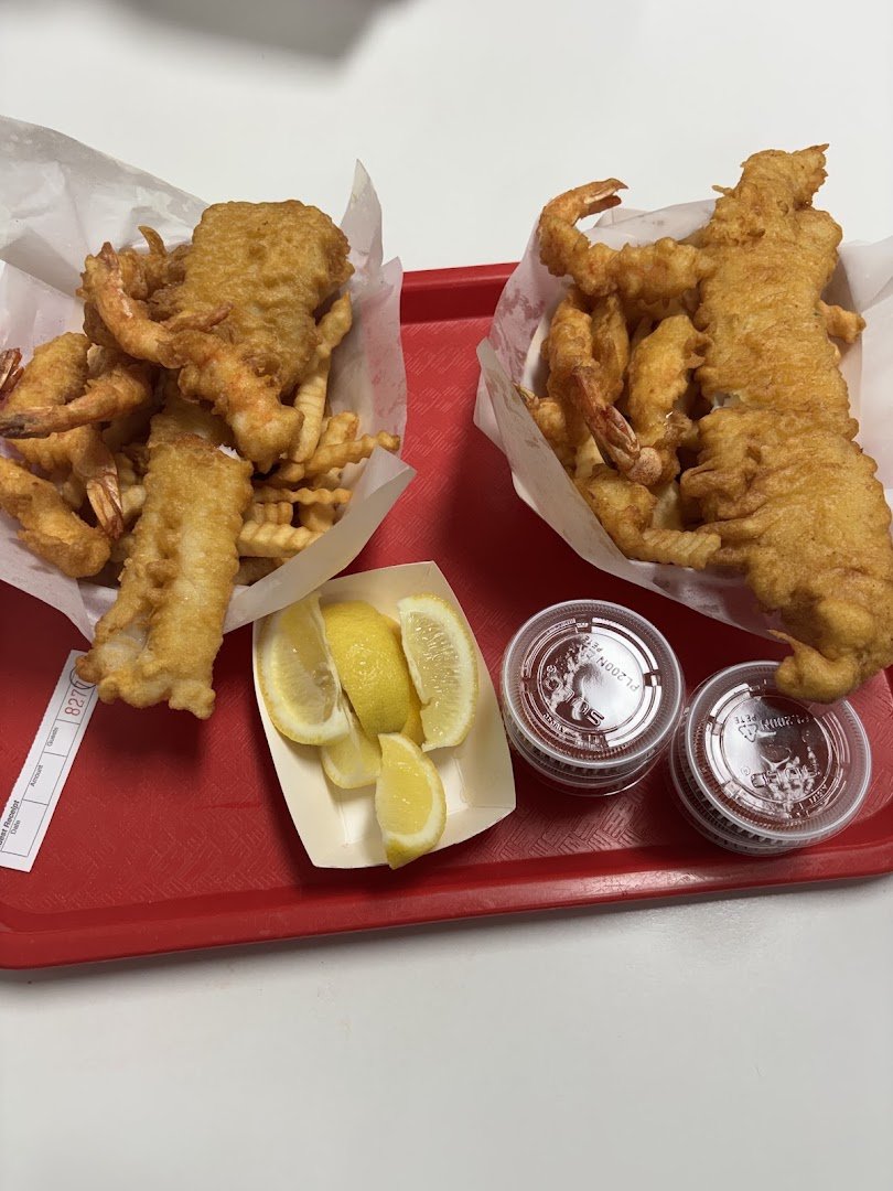 Golden fish and chips on a white plate.